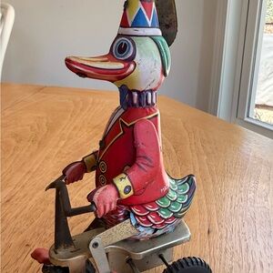 TIN LITHO TOY DUCK ON BICYCLE WITH PROPELLER HAT